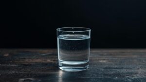 表面張力で溢れそうになっている水のコップ。些細なきっかけで感情が爆発してしまう、40代の精神的な余裕のなさを表現した写真。